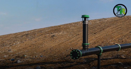 Studnia i rurociąg do gromadzenia gazu składowiskowego na zboczu składowiska odpadów pod błękitnym niebem, z logo TIEROC w prawym górnym rogu.